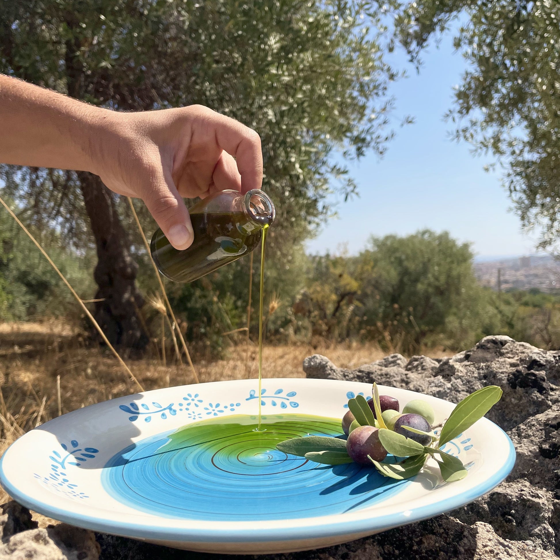 hεvo Olivenöl wird auf einen Teller gegossen, im Olivenhain bei Noto