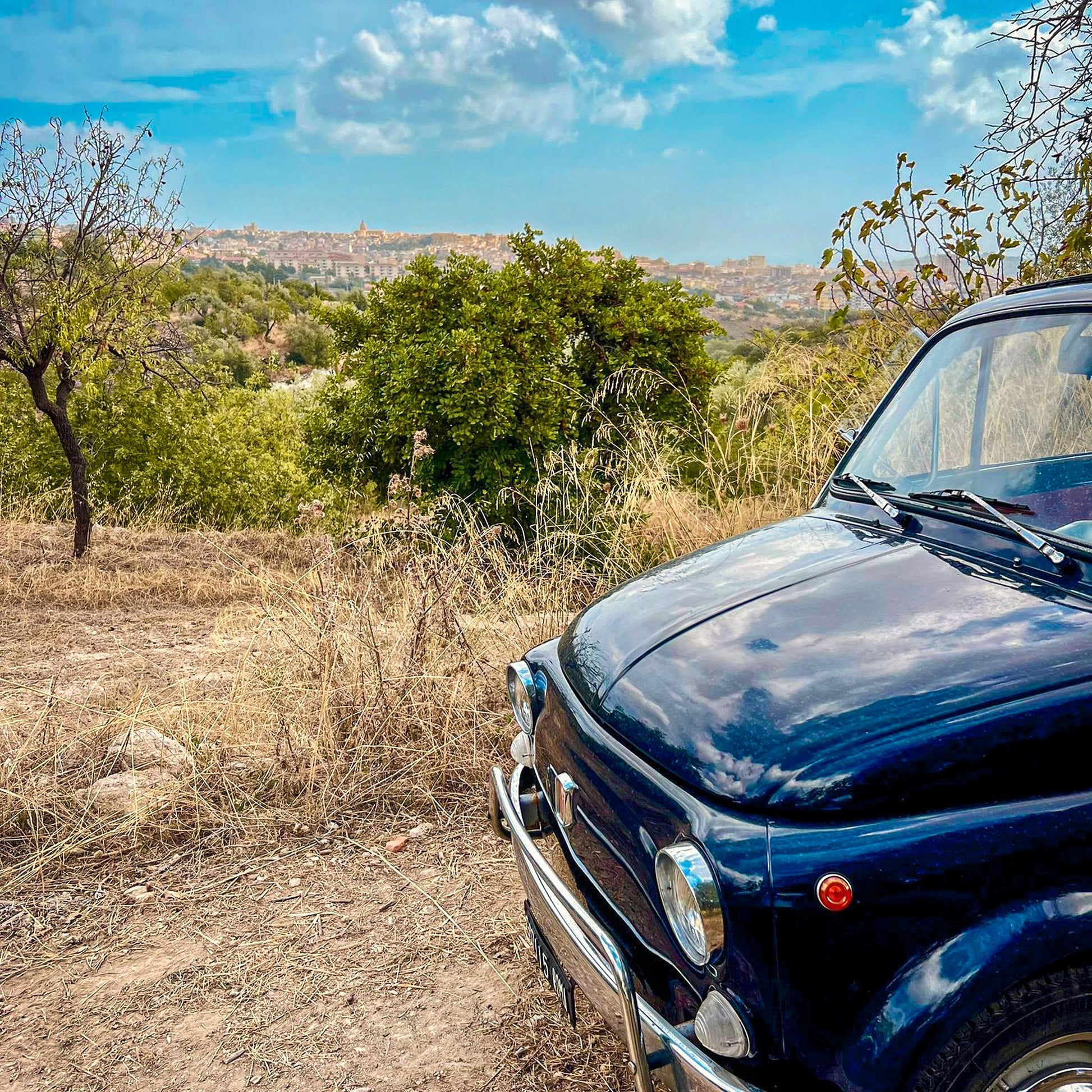 Klassischer Fiat 500 mit Blick über die Landschaft von Noto, Sizilien
